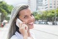 Beautiful woman with blonde hair at phone in the city Royalty Free Stock Photo