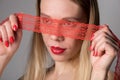 Beautiful woman with lace on eyes on a red background Royalty Free Stock Photo