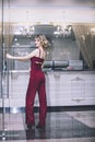 Beautiful woman blonde model in a red jumpsuit a fashionable and