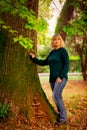 Beautiful woman,blonde,walking in the Park in autumn,in jeans and a green jumper.
