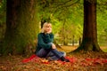 Beautiful woman,blonde,walking in the Park in autumn,in jeans and a green jumper.