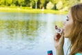 Beautiful woman blowing bubbles in the summer near the lake Royalty Free Stock Photo