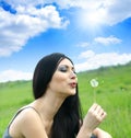 Beautiful woman blowing dandelion Royalty Free Stock Photo