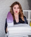 Beautiful woman blowing a kiss while holding an iron at home