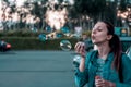 Beautiful woman blowing soap bubbles outdoors. Portrait of young beautiful hipster girl bubble blower in the city Royalty Free Stock Photo