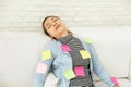 Beautiful woman in blue casual dress Sleeping on white sofa On the body filled with colorful note paper Royalty Free Stock Photo