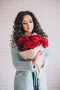 Beautiful woman in blue coat with red roses in craft paper