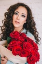 Beautiful woman in blue coat with red roses in craft paper