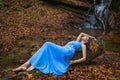 A beautiful woman in blue dress near a waterfall Royalty Free Stock Photo