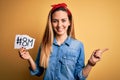 Beautiful woman with blue eyes celebrating 8th march womens day over yellow background very happy pointing with hand and finger to