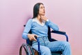 Beautiful woman with blue eyes sitting on wheelchair touching painful neck, sore throat for flu, clod and infection