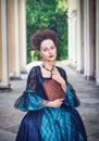 Beautiful woman in blue medieval dress with book