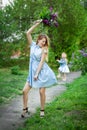 Beautiful woman in a blue summer dress with lilac flowers in a blooming garden. Spring Blossom Royalty Free Stock Photo