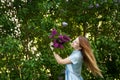 Beautiful woman in a blue summer dress with lilac flowers in a blooming garden. Spring Blossom Royalty Free Stock Photo