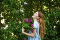 Beautiful woman in a blue summer dress with lilac flowers in a blooming garden. Spring Blossom Royalty Free Stock Photo