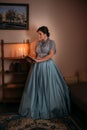 Beautiful woman in blue vintage 1800s early 1900s clothing Cottagecore Edwardian Victorian Epoque dress in old interior