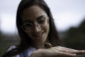 Beautiful woman blurred holding a snail in her hands outdoors