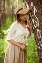 Beautiful woman with a bouquet of daisies near birch Royalty Free Stock Photo