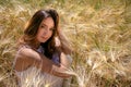 Beautiful woman, bride with blue eyes and brown hair walks through corn field on a sunny summer`s day