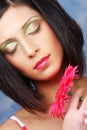 Beautiful woman with bright make up holding pink gerber flower Royalty Free Stock Photo