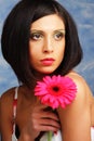 Beautiful woman with bright make up holding pink gerber flower Royalty Free Stock Photo