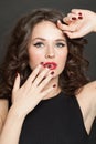 Beautiful woman brunette with red lips and hand with red manicured nail, closeup beauty portrait