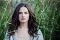 Beautiful woman brunette in spring grass outdoors portrait. Perfect face