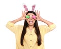 Beautiful woman in bunny ears headband holding Easter eggs near eyes Royalty Free Stock Photo