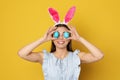 Beautiful woman in bunny ears headband holding Easter eggs near eyes Royalty Free Stock Photo