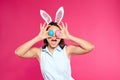 Beautiful woman in bunny ears headband holding Easter eggs near eyes Royalty Free Stock Photo