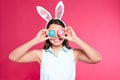 Beautiful woman in bunny ears headband holding Easter eggs near eyes Royalty Free Stock Photo