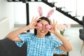 Beautiful woman in bunny ears headband holding Easter eggs near eyes Royalty Free Stock Photo