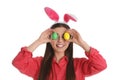 Beautiful woman in bunny ears headband  holding Easter eggs near eyes on white Royalty Free Stock Photo