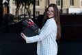 Beautiful woman in business suit and glasses opens gift in surprise. Young woman opened black gift box Royalty Free Stock Photo