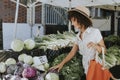 Beautiful woman buying vegetables at a farmers market