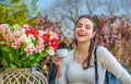 Beautiful woman on a cafe enjoying morning with cup of coffee. She holds a cup, laughing, spring flowers. Woman drink Royalty Free Stock Photo