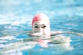 Beautiful woman cap smiling looking to camera at border of swimming pool Royalty Free Stock Photo