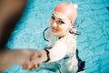 Beautiful woman cap smiling looking to camera at border of swimming pool Royalty Free Stock Photo