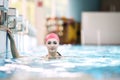 Beautiful woman cap smiling looking to camera at border of swimming pool Royalty Free Stock Photo