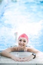 Beautiful woman cap smiling looking to camera at border of swimming pool Royalty Free Stock Photo