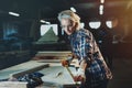 Beautiful woman carpenter designer works with ruler, make notches on the tree in workshop. Image of modern femininity. Concept o Royalty Free Stock Photo