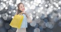 Beautiful woman carrying shopping bags over bokeh Royalty Free Stock Photo