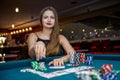 Beautiful woman in casino taking chips from pile