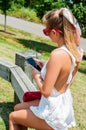 Beautiful woman with cellphone having a rest in the park. Royalty Free Stock Photo