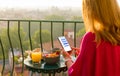 Woman chatting on phone at breakfast on terrace Royalty Free Stock Photo