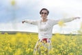 Beautiful woman cheering in rapeseed field and enjoying summer Royalty Free Stock Photo