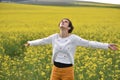 Beautiful woman cheering in rapeseed field and enjoying summer Royalty Free Stock Photo