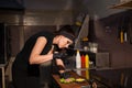 Beautiful woman chef prepares a hamburger in the kitchen of the restaurant Royalty Free Stock Photo