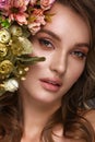 Beautiful woman with classic nude make-up, light hairstyle and flowers. Beauty face. Royalty Free Stock Photo