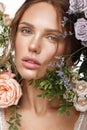 Beautiful woman with classic nude make up, light hairstyle and flowers. Beauty face. Royalty Free Stock Photo